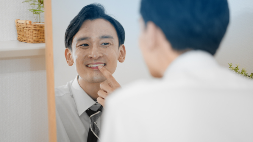 歯周病を治療して鏡で確認する男性