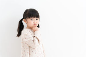 顎に手を当てて考える女の子