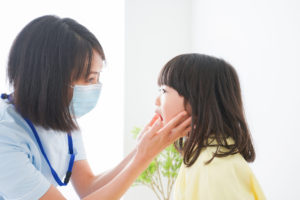 女性歯科医師に口の中を見てもらう女の子