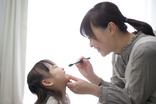 子供の歯をみがく母親