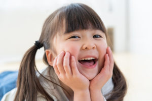 頬杖をついて笑う日本人の女の子