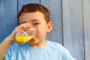 オレンジジュースを飲む男の子